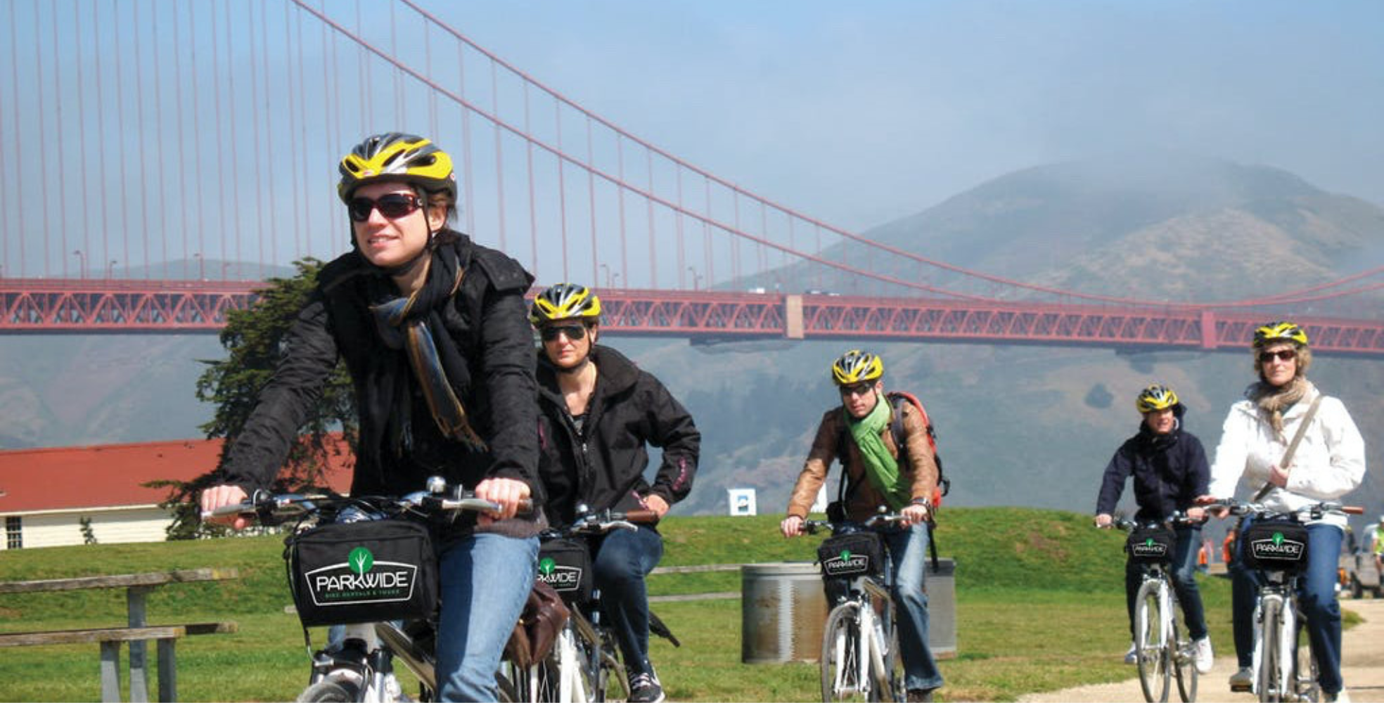 group biking through golden gate park under the golden gate bridge along the Golden Gate Promenade