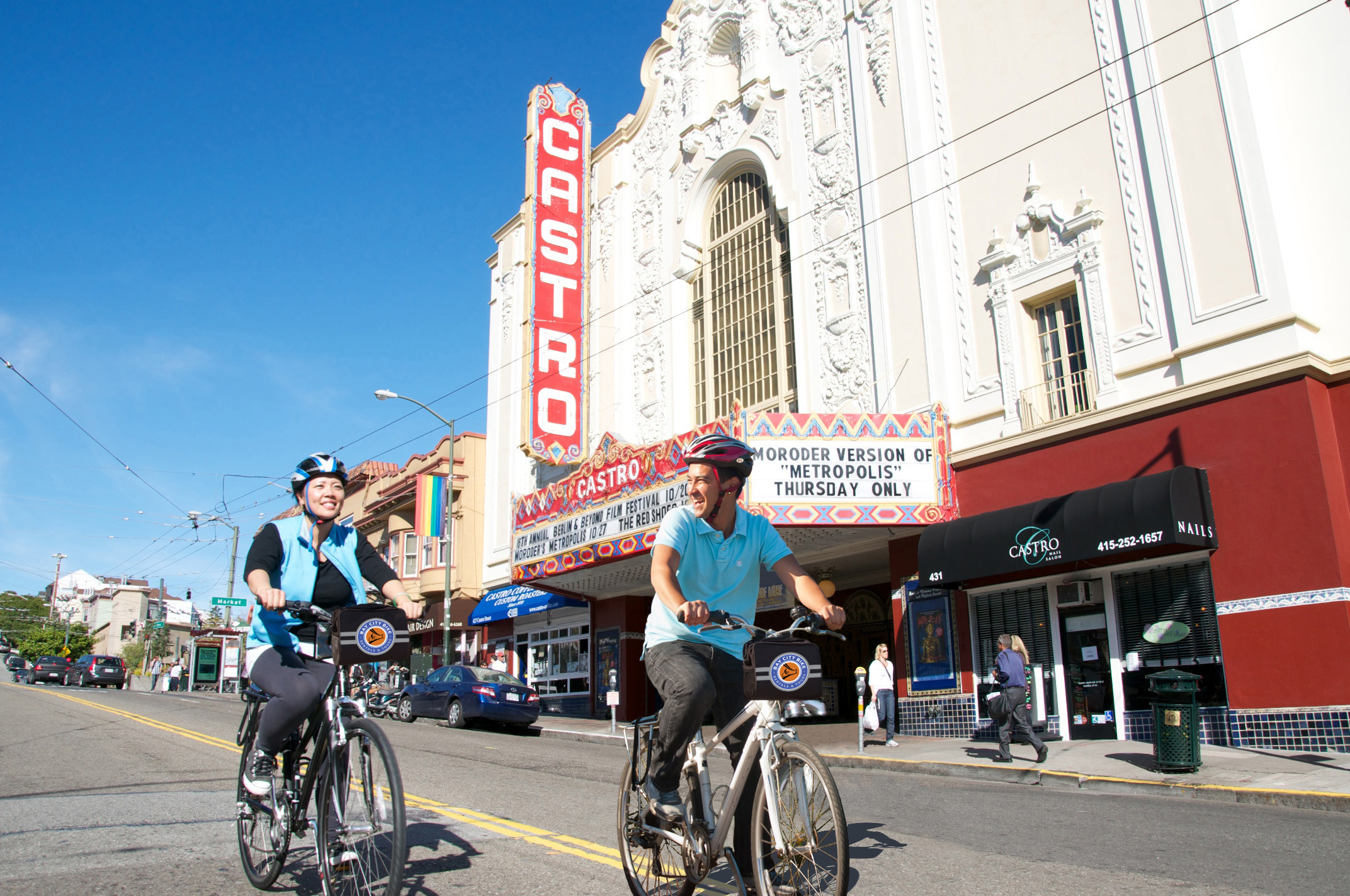 couple on sf bike rentals biking past the castro theatre