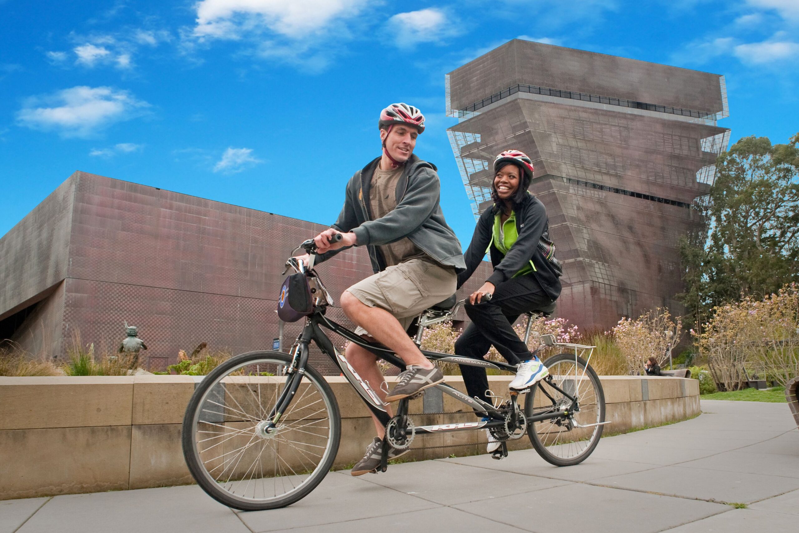 couple on tandem bike rental biking past the De Young Museum